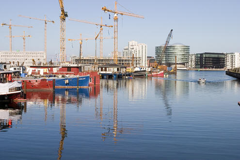 Udsigt over Tømmergraven mod Havneholmen. I venstre side ligger der husbåde og i højre side (kan ikke ses) Kbh's Roklub. På Havneholmen bygges der stadig - deraf masser af kraner.